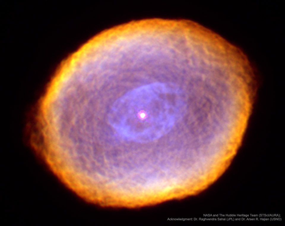 A complex orange and purple nebula with a complex
texture is shown in front of a dark starfield.
Please see the explanation for more detailed information.