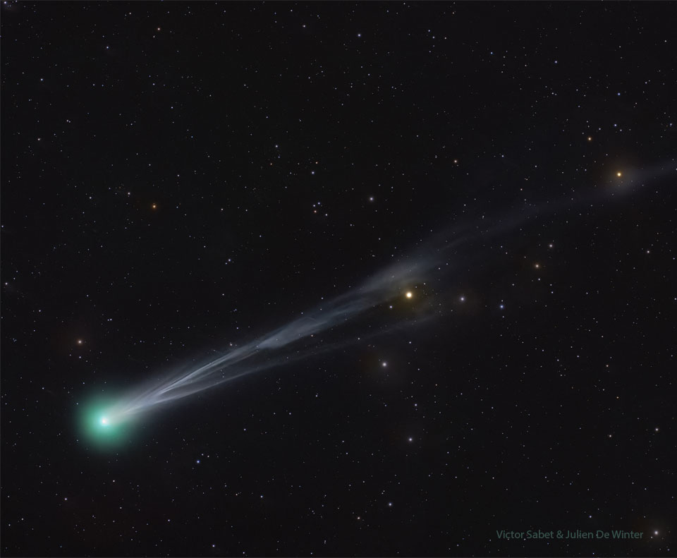 A starfield is shown that has a bright comet.
The comet shows a green head on the lower left and
an ion tail with significant structure extending out
to the upper right. 
Please see the explanation for more detailed information.