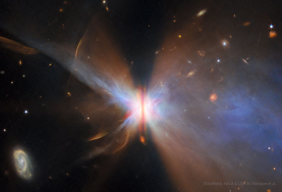 A starfield surrounds a nebula with a vertical brown bar
across its centre. Gas and dust fan out from the bar
making the nebula appear like a colourful butterfly. 
Please see the explanation for more detailed information.
