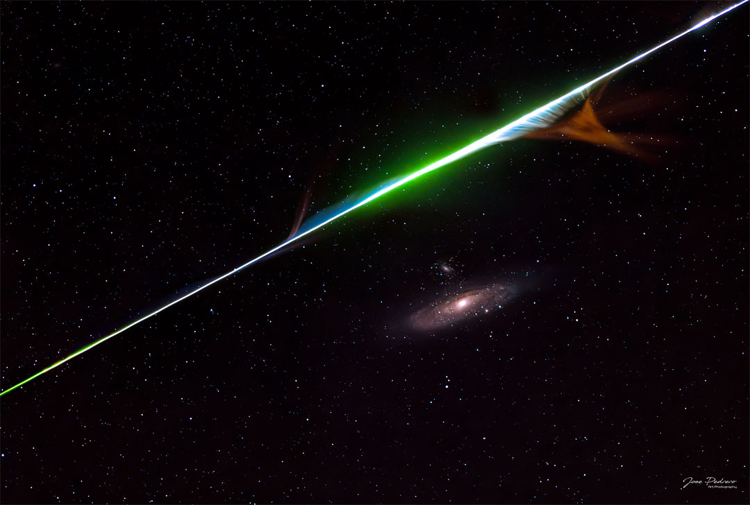 A colour meteor streak is seen above the Andromeda spiral galaxy.
Please see the explanation for more detailed information.