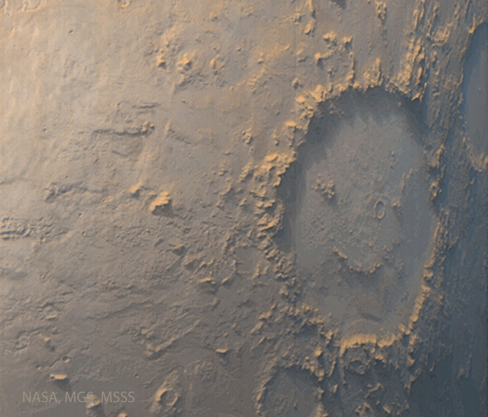 Several craters are visible on a tan surface. 
The largest crater, on the right, has internal 
markings that make it look like a winking face
with a smile. 
Please see the explanation for more detailed information.