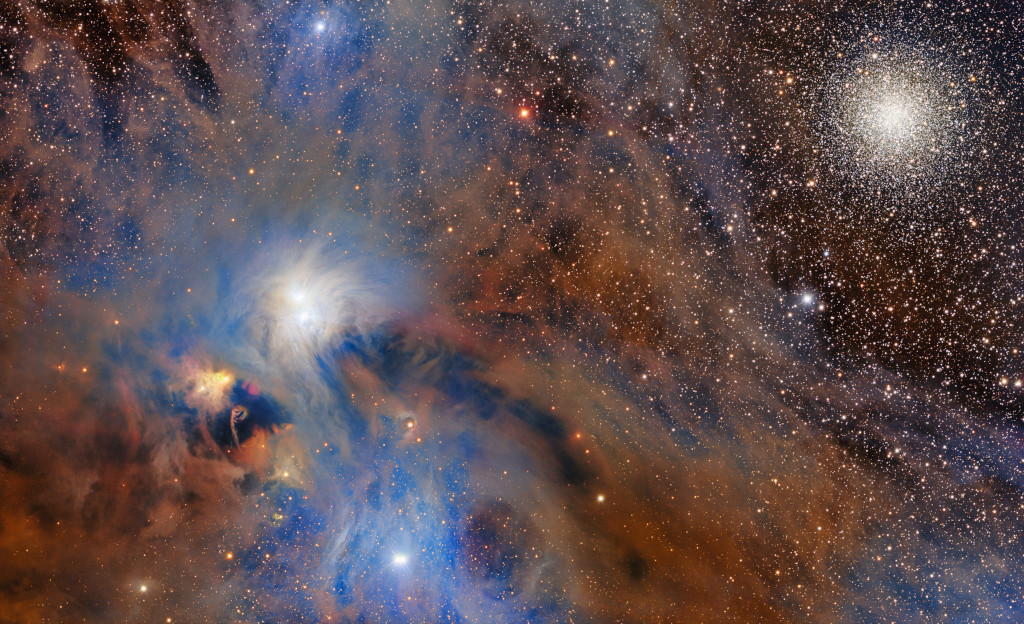 Both dense and whispy clouds streak across the left side of the image with bright stars peaking through. A few stars stand out as brighter than the rest. A tight cluster of stars sits to the top right of the image. The background is covered with stars.
