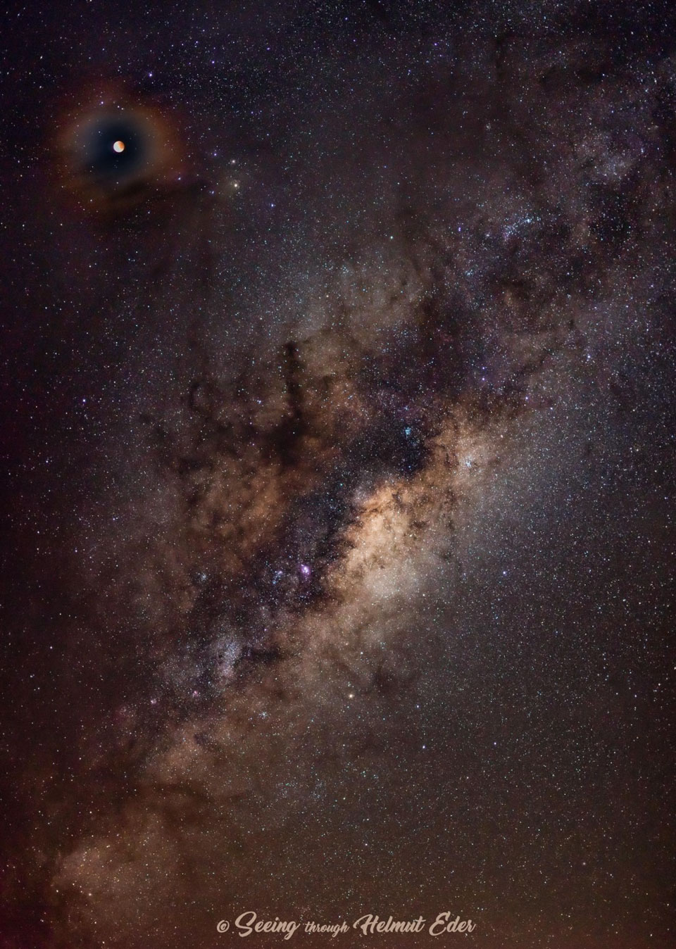 The picture shows total lunar eclipsed moon surrounded by a colourful atmospheric corona. 
Please see the explanation for more detailed information.