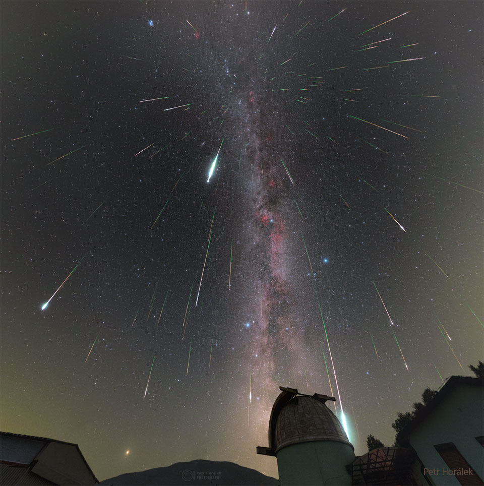 Mulitple streaks cover a night sky filled with stars.
An observtory dome is visible in the foreground. 
Please see the explanation for more detailed information.