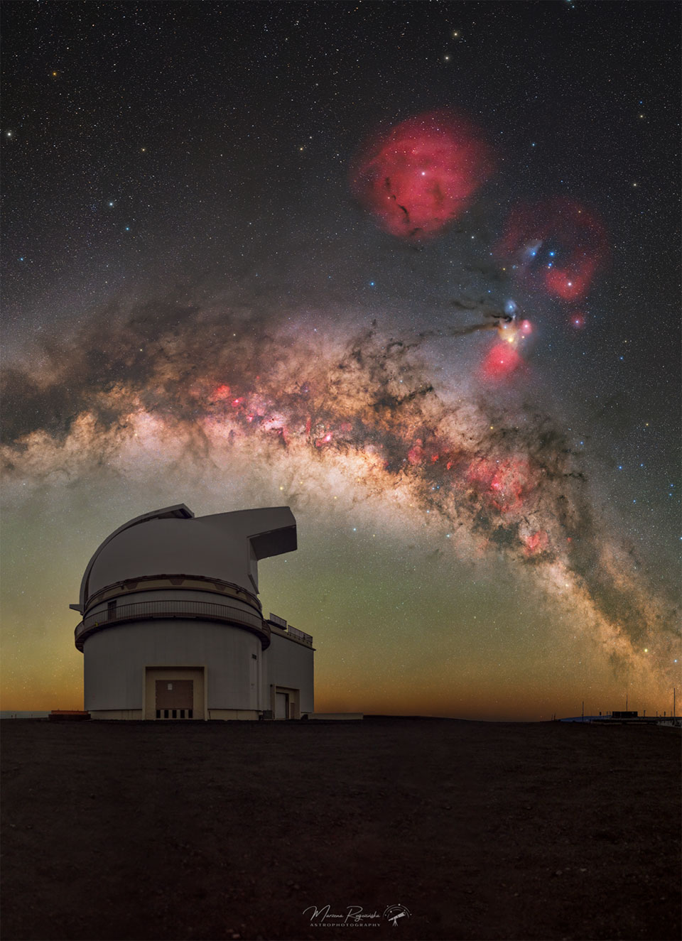 A wide starfield is shown with the dark and light
band arching horizontally across the middle. On the right
is a colourful and complex nebula, and near the top 
centre is a red circular nebula.
Please see the explanation for more detailed information.