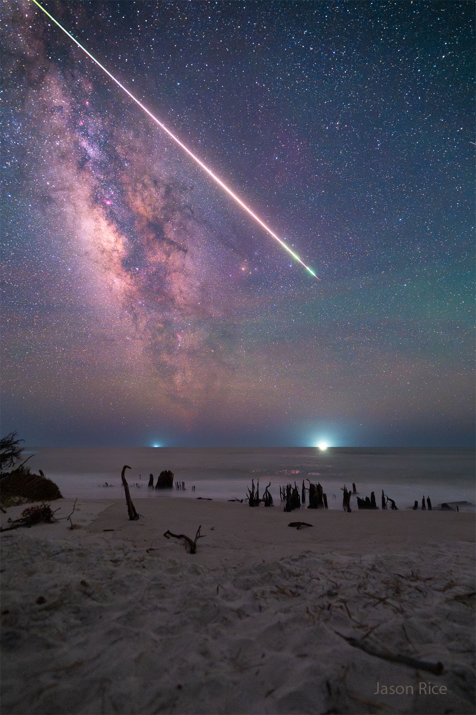 A bright streak is pictured through a starry sky over a 
beach spotted with the husks of dead trees. The rollover
shows the resulting smoke trail from the bright meteor.
Moving the cursor over the image will bring up an annotated version.
Clicking on the image will bring up the highest resolution version
available.
Please see the explanation for more detailed information.
